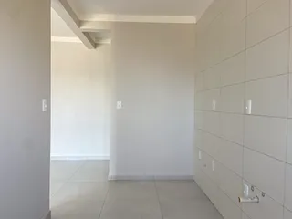 Hall de corredor com paredes brancas e piso de cerâmica.