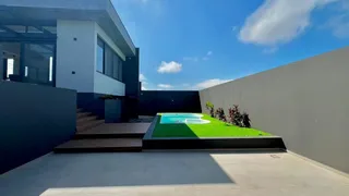 Foto da piscina com gramado verde em uma residência moderna.