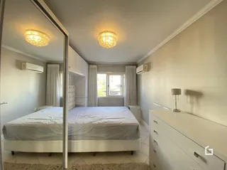 Quarto com cama de casal e paredes brancas em um imóvel.