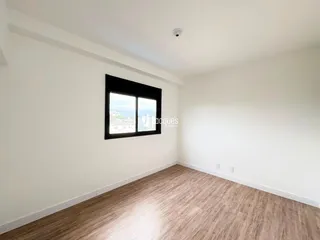 Ambiente interno com piso de madeira clara e parede branca.
