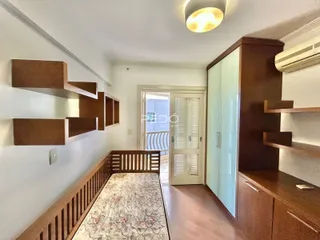 Quarto com cabeceira de madeira e armário em um imóvel no Brasil.
