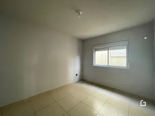 Uma sala com piso de cerâmica e janela em uma residência.