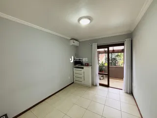 Vista interna de um corredor com piso de cerâmica e parede clara.