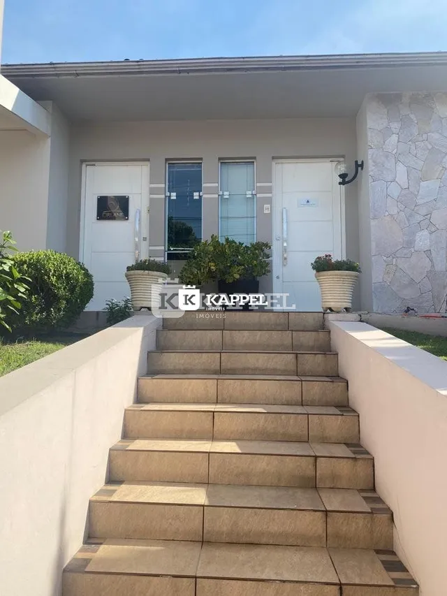 Fachada da casa com escadaria externa de pedra.