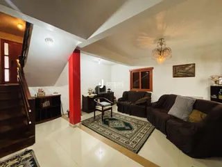 Interior de uma sala de estar com piso claro e móveis de madeira.