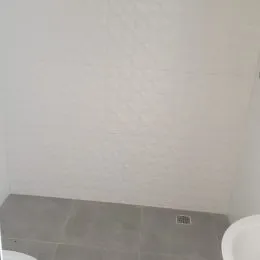 Foto de uma parede branca e piso claro em um ambiente interno.