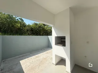 Uma vista de uma área externa com piso de concreto e parede branca.