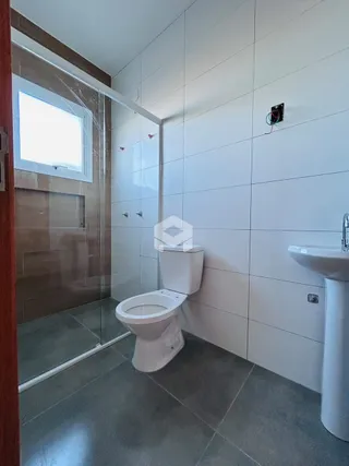 Foto de um banheiro com box de vidro e piso de cerâmica.