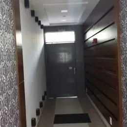 Corredor interno com paredes escuras e piso escuro.