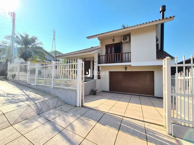 Fachada de uma residência em Lajeado, Brasil, com cerca e portão brancos.