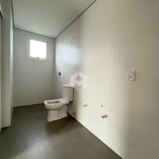 Foto de um banheiro interno com piso de cerâmica e paredes brancas.