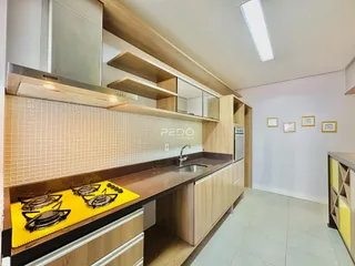 Cozinha moderna com armários de madeira e revestimento de cerâmica.