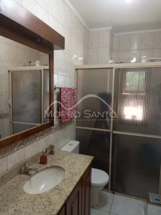 Foto de uma bancada com pia e revestimento de azulejos em uma área de cozinha.