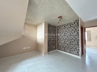 Interior de um ambiente com teto inclinado e papel de parede estampado.