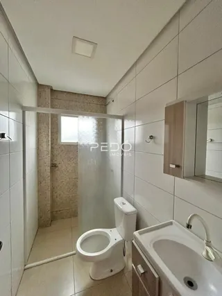 Foto de um banheiro interno com revestimento cerâmico e louças sanitárias.