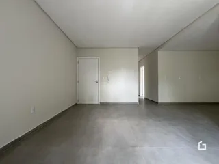 Interior de um cômodo com paredes brancas e piso cinza.