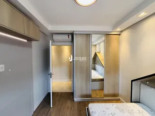 Quarto com armários embutidos e piso de madeira.