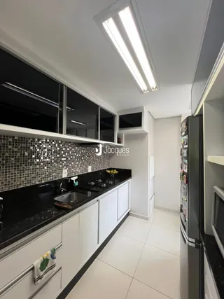 Cozinha moderna com armários pretos e bancadas escuras.