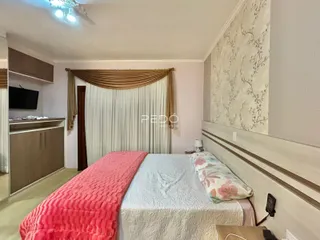 Quarto com cama e cortinas em um ambiente claro.