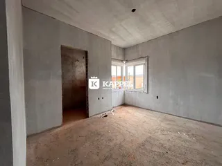 Foto de um ambiente interno com paredes de concreto e uma janela.