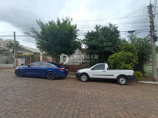 Foto da fachada de uma propriedade em Lajeado, Brasil, com veículos estacionados na frente.