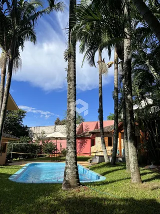 Vista do jardim com piscina e palmeiras em Lajeado, Brasil.