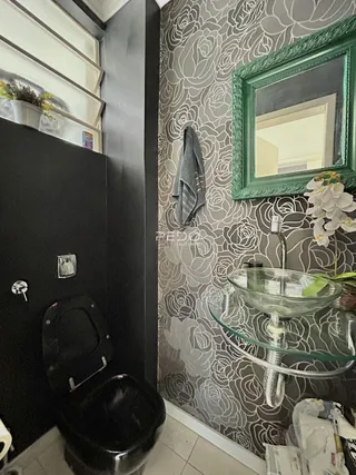 Interior de um ambiente com parede decorada em padrão floral e espelho.