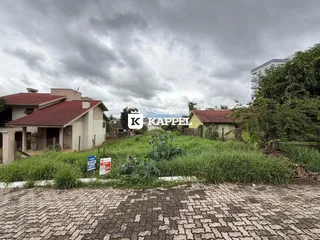 Vista externa de uma residência em Lajeado, Brasil, com vegetação alta no primeiro plano.