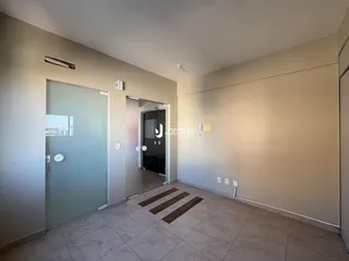 Hall de entrada com piso de cerâmica e porta de vidro.