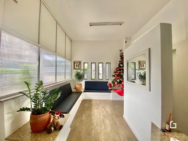Uma sala de estar com grandes janelas e piso de madeira.