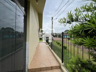 Vista da fachada de uma residência com muro e cerca de ferro.