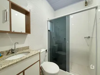 Banheiro com box de vidro e louças sanitárias em um imóvel.
