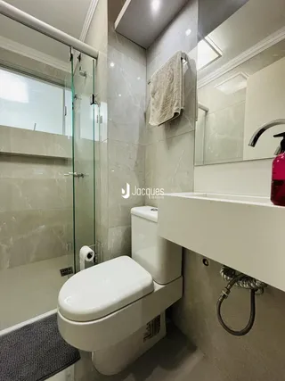 Foto de um banheiro moderno com box de vidro e revestimento de mármore.