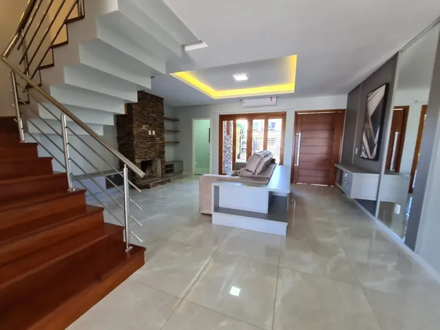 Vista de uma escadaria com degraus de madeira em um hall de residência.
