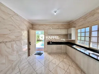 Foto de uma cozinha com armários brancos e piso de cerâmica.