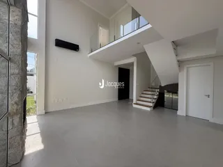 Ambiente interno moderno com pé direito alto e piso claro.