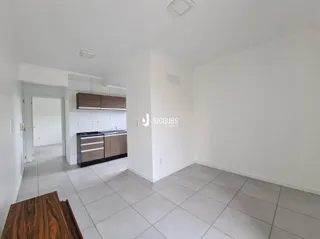 Foto do interior de uma sala com piso de cerâmica clara e armários de madeira.
