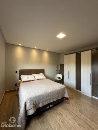 Quarto com cama e armário de madeira no interior da residência.