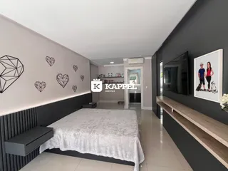 Quarto com cama grande e cabeceira escura em um ambiente moderno.