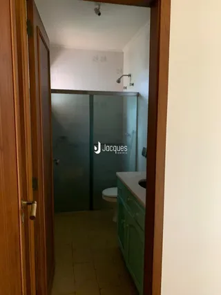 Vista de um banheiro com box de vidro e piso cerâmico em uma residência.