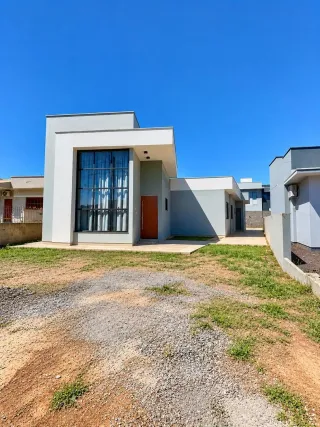 Fachada externa de uma residência moderna em Lajeado, Brasil, com paredes claras e telhado plano.
