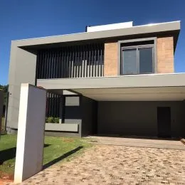 Fachada moderna de uma residência em Lajeado, Brasil, com revestimento em tons neutros.