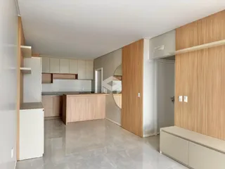 Ambiente interno de uma sala de estar com cozinha moderna.