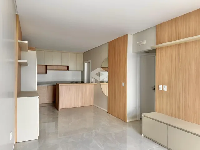 Ambiente interno de uma sala de estar com cozinha moderna.
