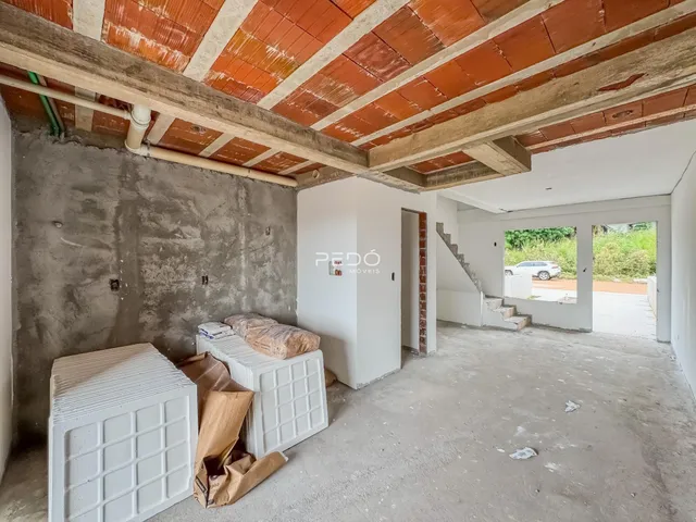 Interior de uma área em construção com teto de telhas exposto.