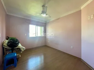 Sala de estar com piso de madeira clara e paredes em tom de rosa.