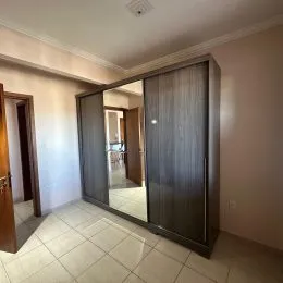 Hall de entrada com revestimento de madeira e piso claro.