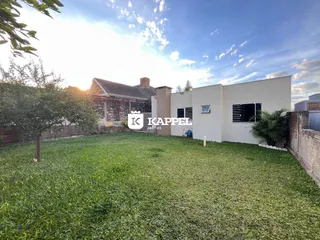 Vista externa da residência em Lajeado, Brasil, com um extenso gramado em primeiro plano.