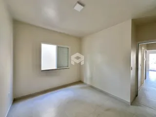 Foto de um cômodo interno com paredes brancas e piso de cerâmica.