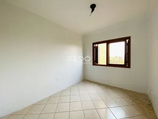 Foto de um cômodo interno com paredes brancas e piso de cerâmica.